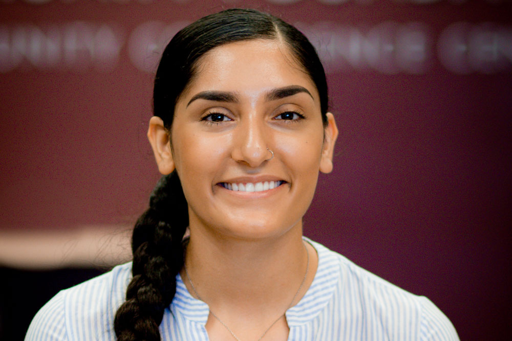 Scholarship recipient Citlali Montanez, a young woman with long dark hair braided on her right shoulder, smiles at the camera wearing a blue and white striped cotton blouse.