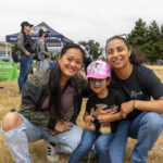 A family with a small child hug one another at the pride celebration