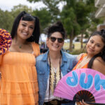Jenesis Diwa and Solicia Aguilar from LGBTQ Connection smile with another attendee of the pride celebration